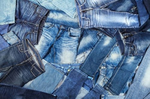 Viele Hosen in Blautönen aus Jeans-Stoff übereinanderliegend