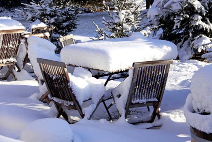 Sitzgruppe aus Holz unter dicker Schneedecke